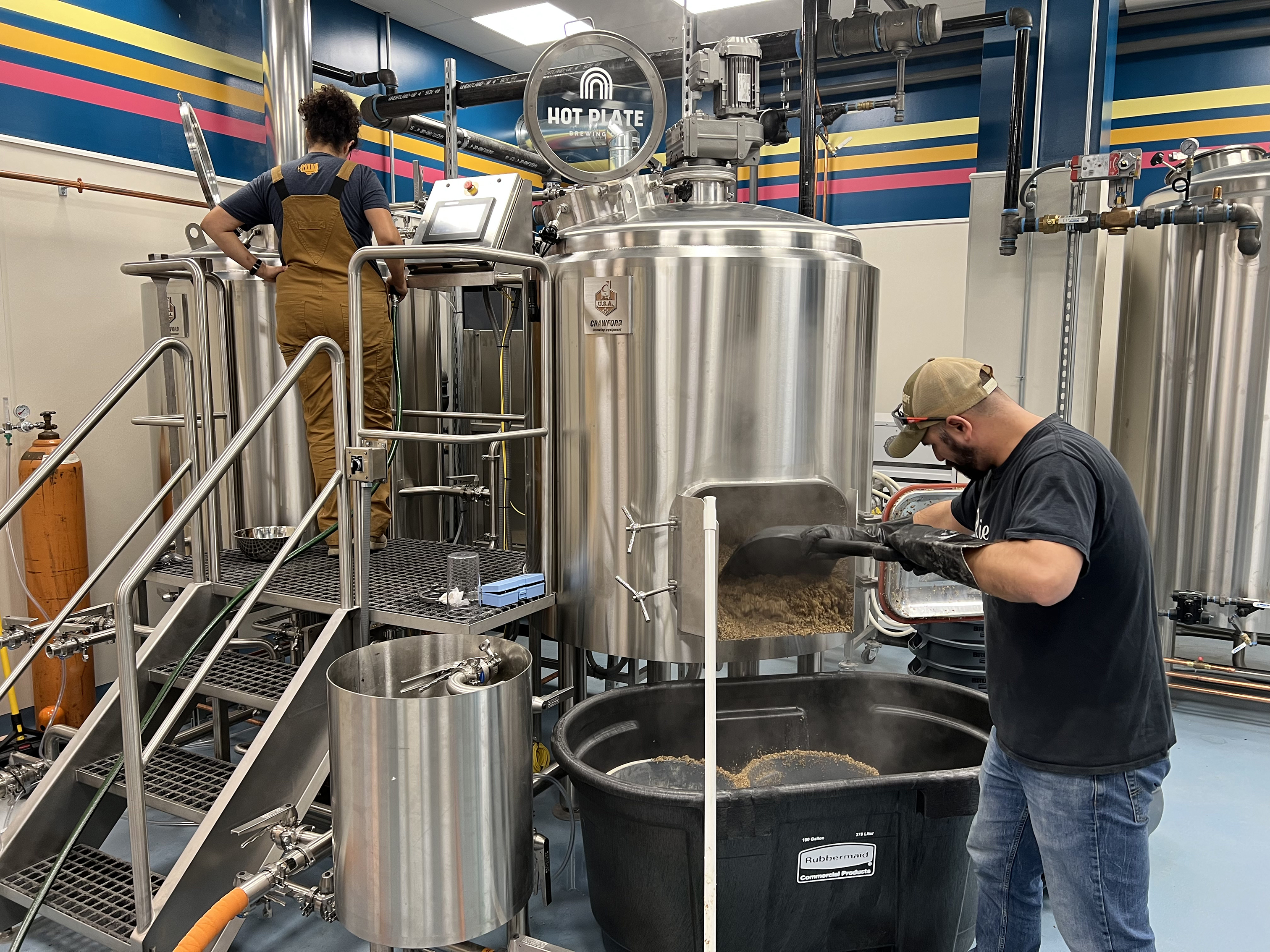 Hot Plate brew house equipment in use making beer. Owner extracting spent grain.